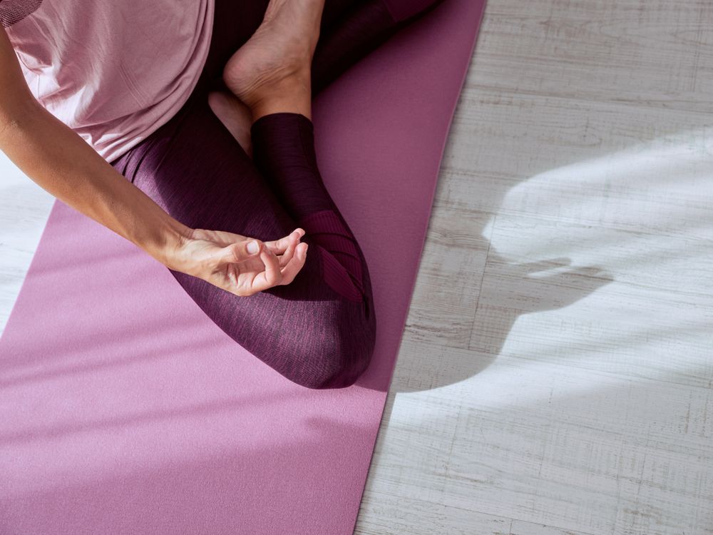 Crop woman meditating in padmasana pose