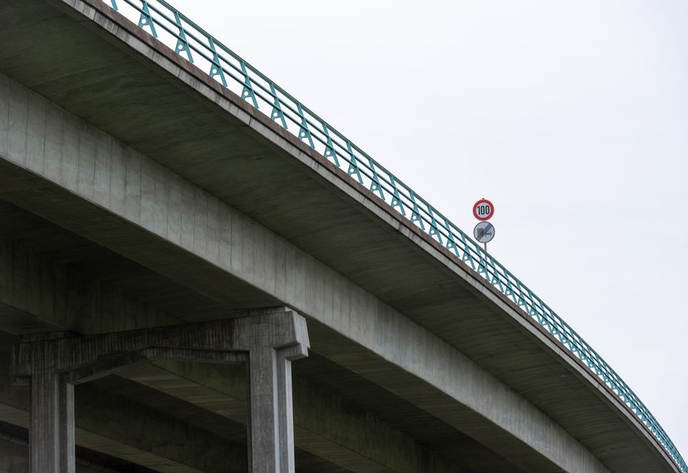 Highway bridge with speed limit sign, low-angle view, in Stuttgart, Germany.