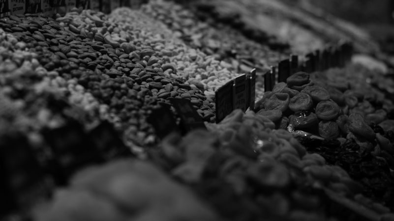 Grayscale photo of piles of nuts at a market