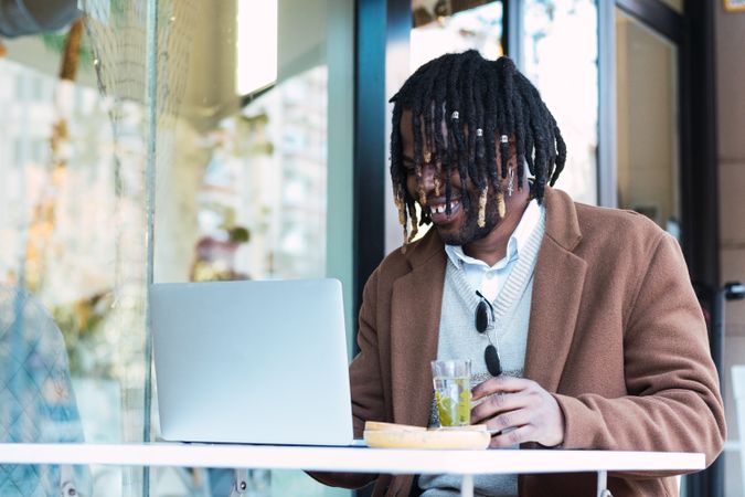 Serious Black man with espresso and glass of water in cafe