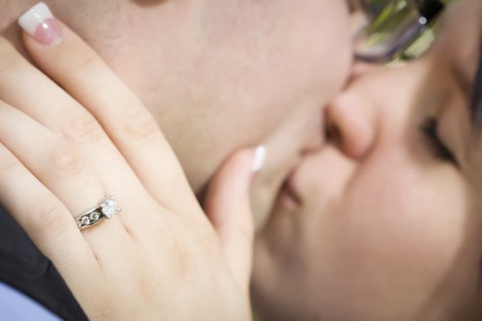 Female Hand with Engagement Ring Touching Fiance's Face