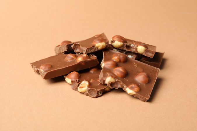 Chocolate pieces on beige background. Sweet food