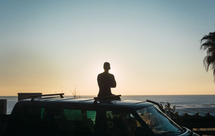 Man enjoying the sunrise in his camped van
