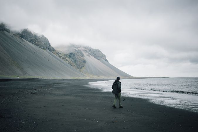 Man walking on rocky coast on a winter’s day