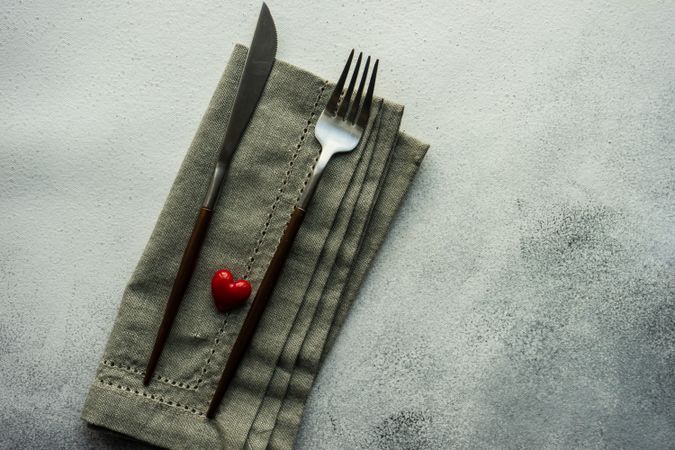 Heart decoration on grey napkin and cutlery