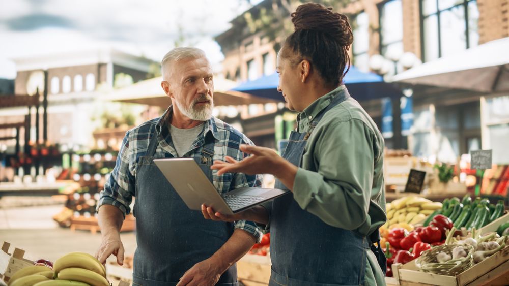 Female and Male Business Partners Managing a Successful Organic Farmers Market Marketplace.