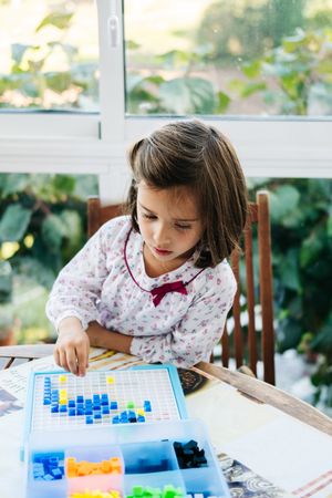Girl playing with mosaic board game