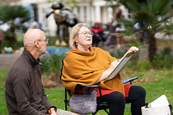 Woman and instructor sitting outside during drawing class