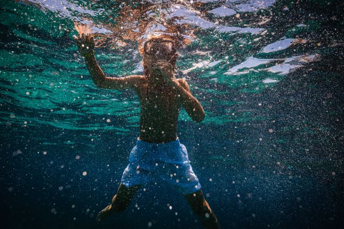 Boy in mask swimming underwater