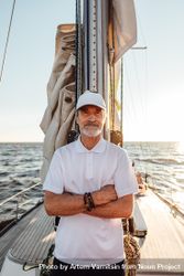 Portrait of older man with arms cross on sailboat at sunset 0Jy2lb