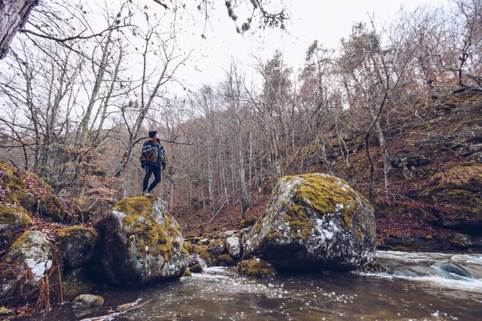 Female tourist standing on rock at autumn forest