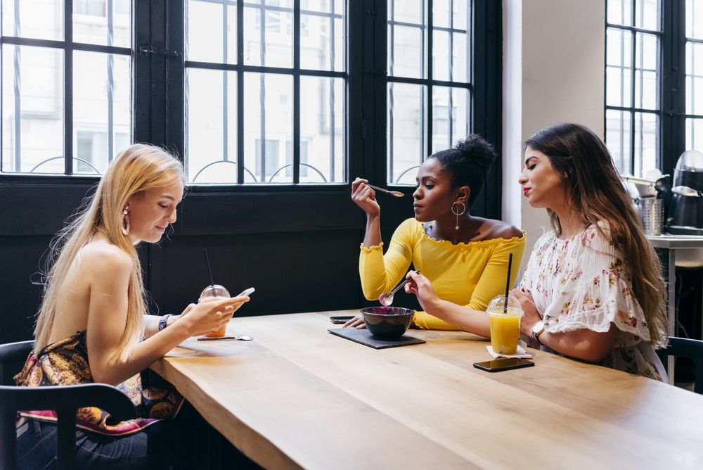 Three female friends having lunch at cafe