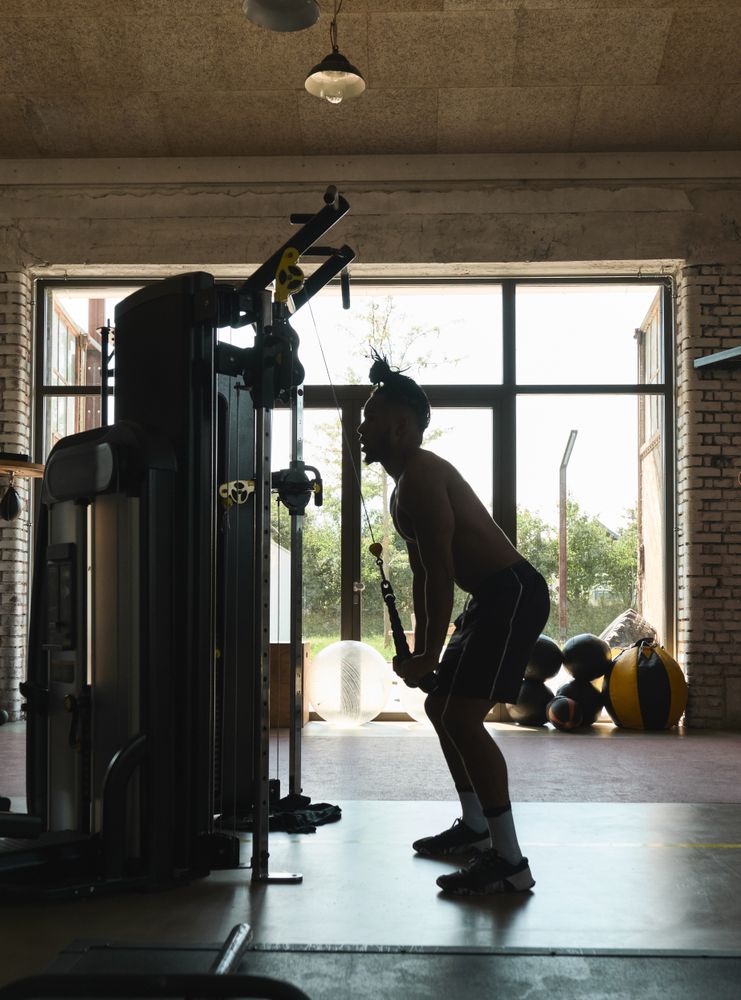 Black guy using exercise machine in gym