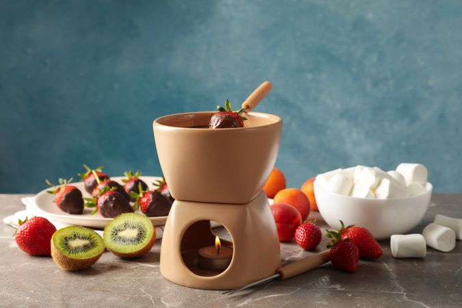 Composition with ingredients for chocolate fondue on gray table. Cooking fondue