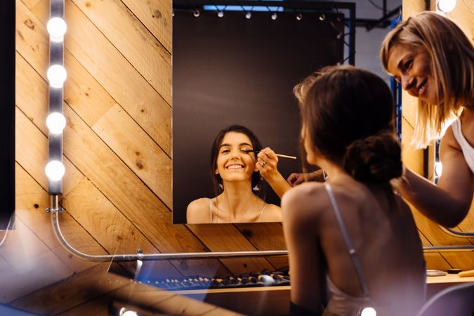 Makeup artist doing makeup for young female artist