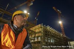 Construction worker beside a building under construction at night 4Zrjn4