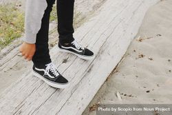 Cropped image of person wear dark sneakers standing outdoor 4mKxe0