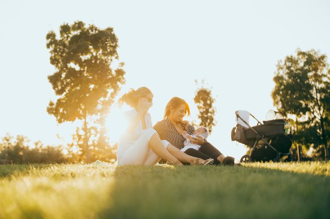 mother and daughter in the park with a baby