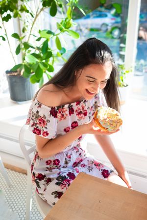 Woman enjoying tasty donut in cafe