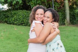 Young mother and teenage daughter hug and smile at the camera