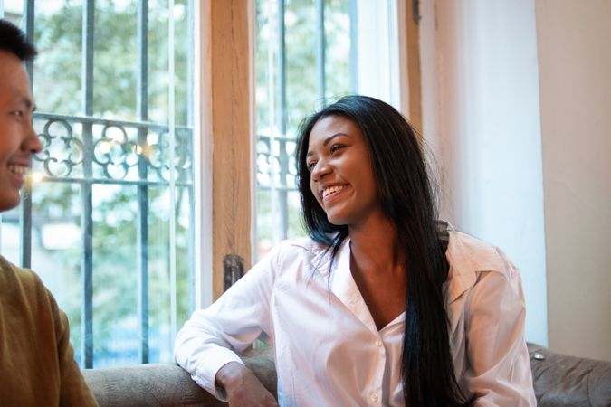 Smiling Black Latina woman talking on a date with an Asian man
