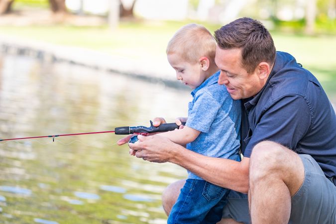 Young Father and Son Having Fun Fishing At The Lake