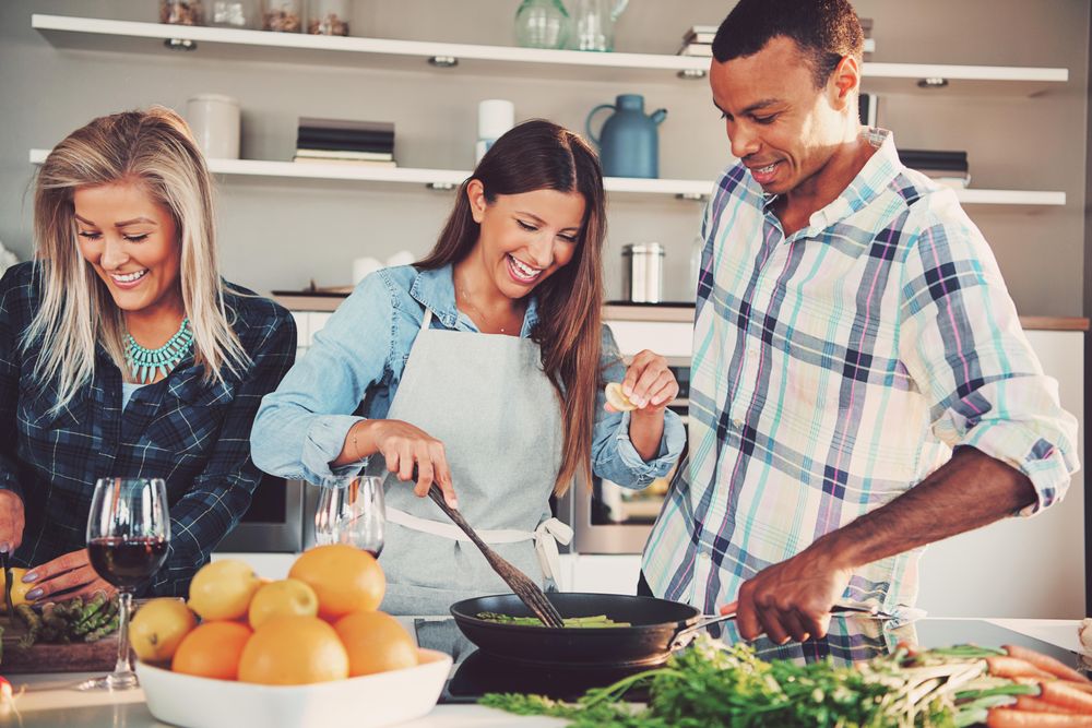Multi-ethnic group of people cooking asparagus in a bright kitchen