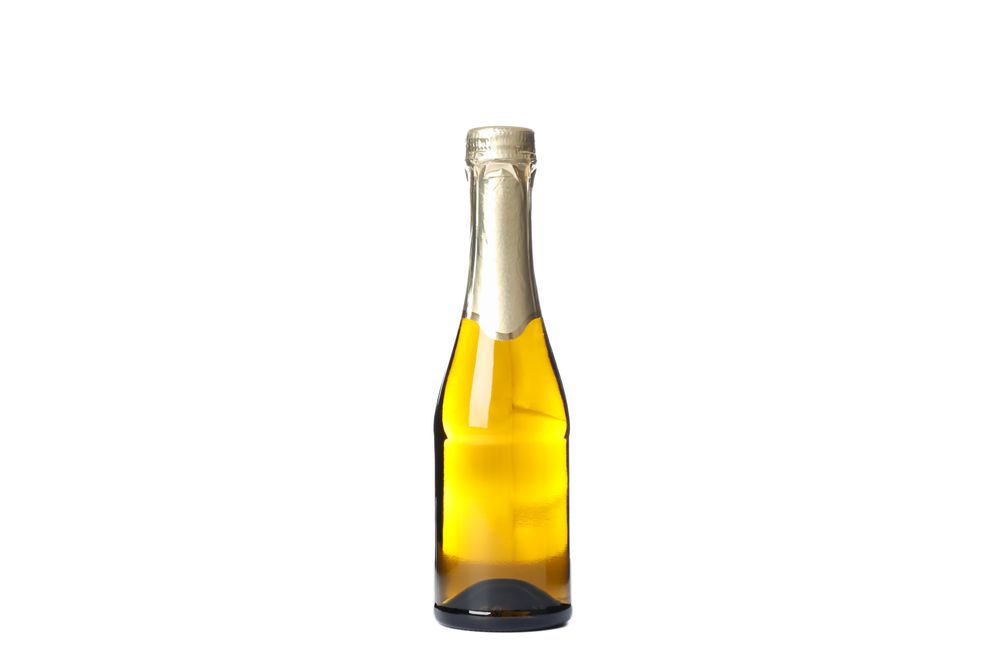 Mini champagne bottle isolated on light background. Celebration drink
