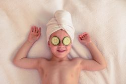 Delighted boy with cucumber on eyes