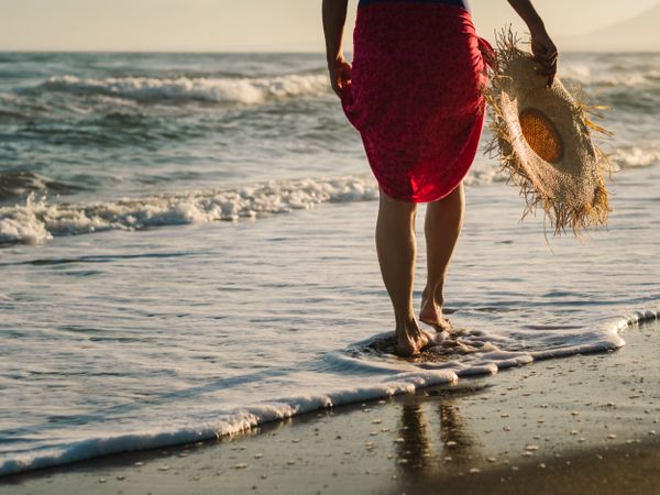 Woman with pink pareo on sandy beach