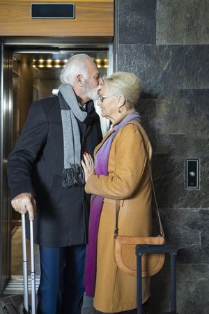 Cute mature couple having a tender moment outside of an elevator