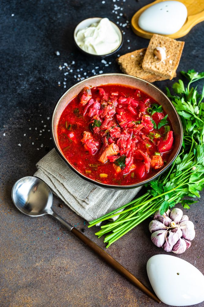 Ukrainian beetroot soup borscht on grey counter, vertical