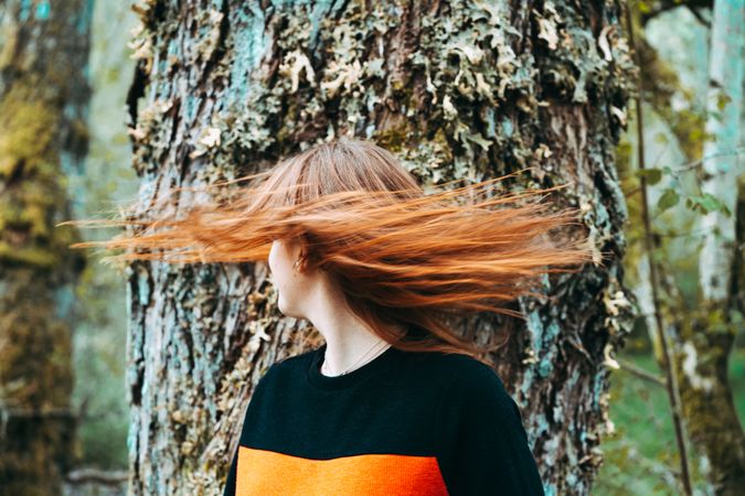Casual redhead woman shaking with hair