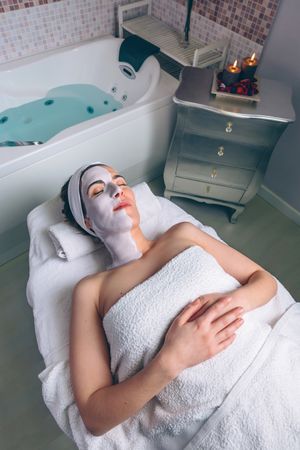 Woman resting in spa with face mask