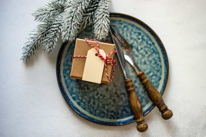 Top view of Christmas table setting of blue plate with gift