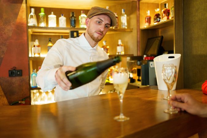 Bartender pouring bubbly into glasses