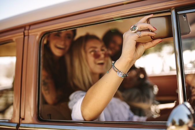 Women making memories of fun road trip while taking a selfie