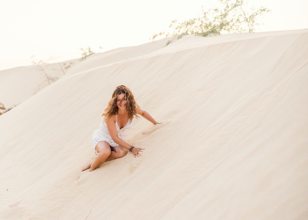 Woman sitting on sand in desert
