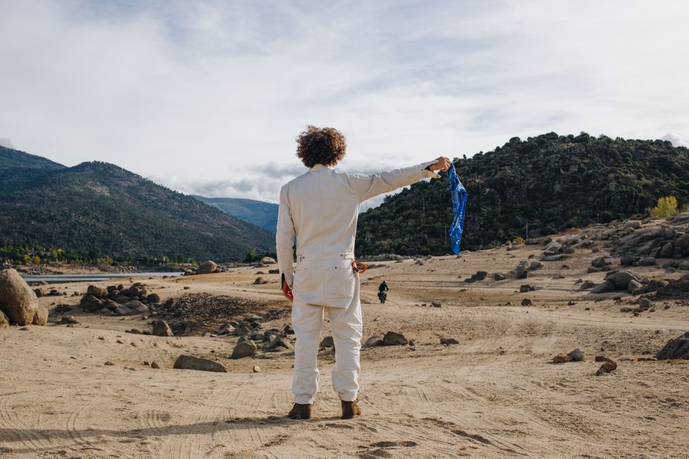 Back of man in jumpsuit waving blue flag