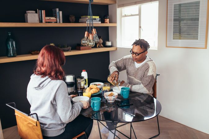 Young couple having breakfast together at home