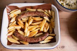 A dish with baked sausages and potatoes, fresh salad