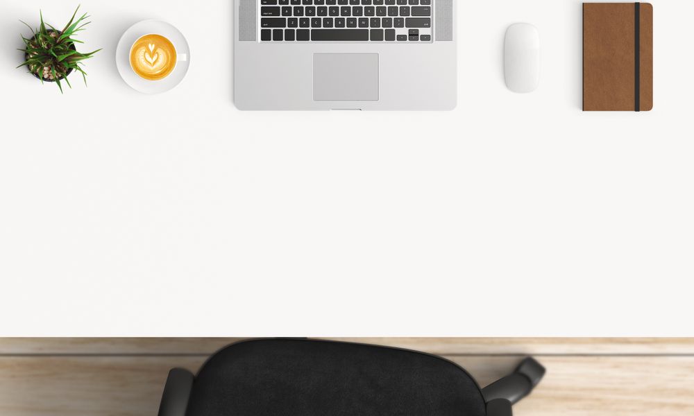 Modern workplace with laptop, coffee cup and notebook copy space on table background. Top view. Flat lay style.