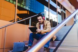 Man using tablet on steps