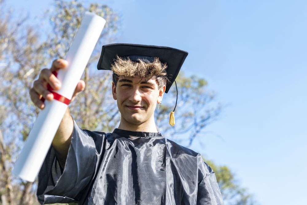 Happy graduated young man wearing a bachelor gown