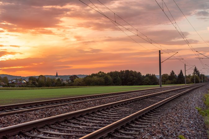 Railroad tracks at sunrise near a german village