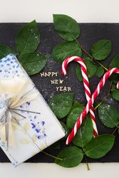 inscription of new year on a board with nice gift and red candy