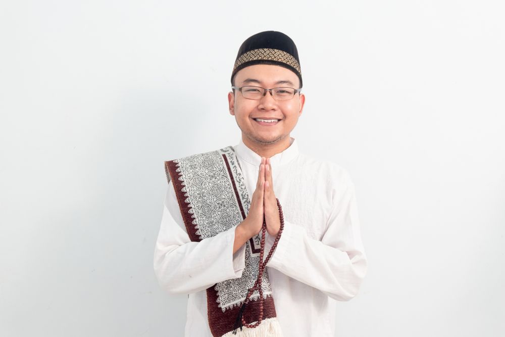 Asian Muslim man smiling doing greeting pose during Ramadan