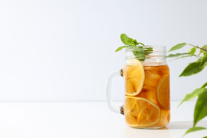 A glass of delicious cold tea on a plain background