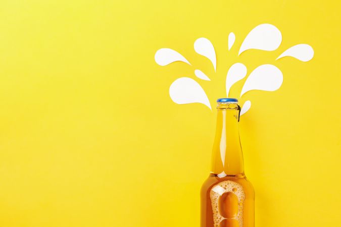 Bottle of beer on yellow background, space for text