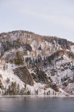 Wide Siberian river and snowy mountains